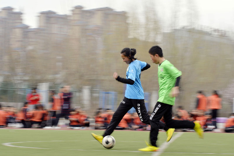 4月10日,呼和浩特市新城区山水小学男女足球队的队员在进行足球比赛。