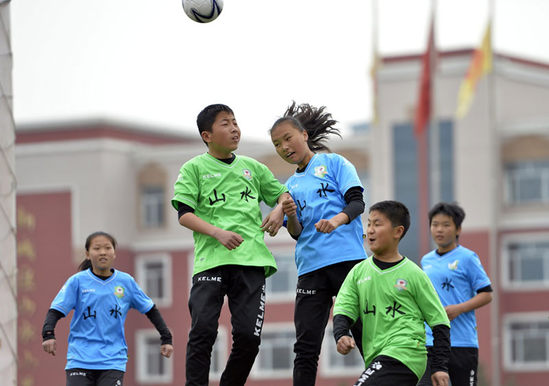 4月10日,呼和浩特市新城区山水小学男女足球队的队员在进行足球比赛。