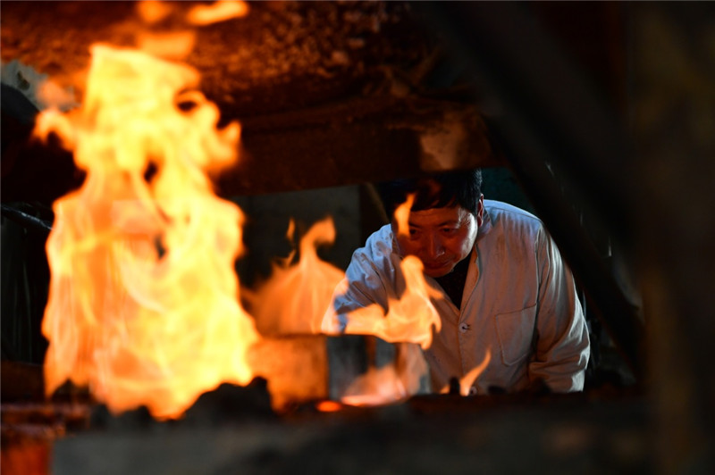 4月12日,在河南省西平县,棠溪宝剑锻制工艺传承人高庆民的徒弟张耀广在加热剑胚,做锻打前的准备。