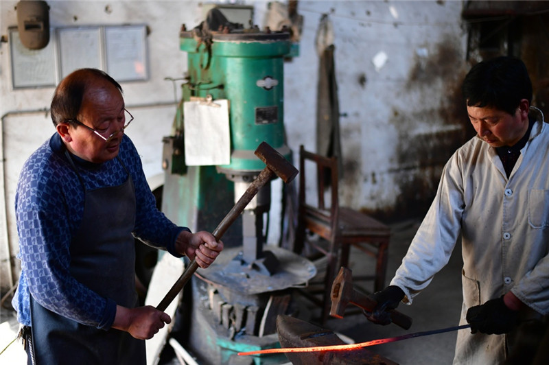 4月12日,在河南省西平县,铸剑师傅在锻打剑条。