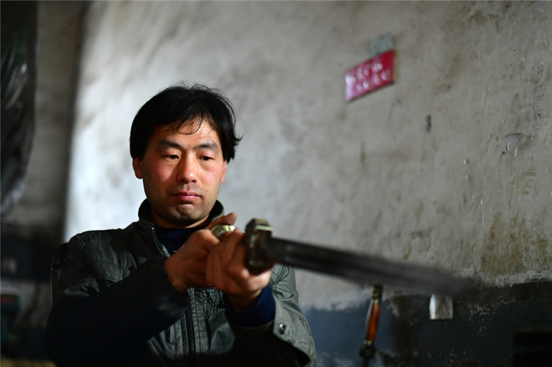 4月12日,在河南省西平县,铸剑师傅在组装宝剑。