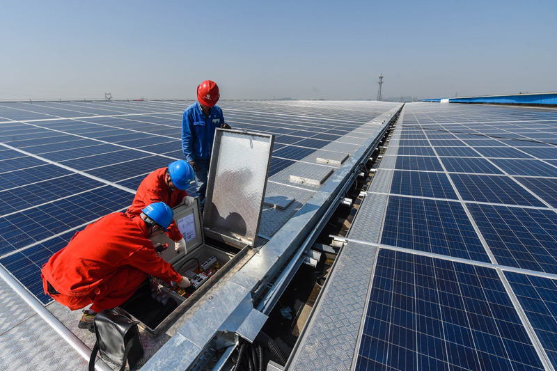 4月13日，工作人员在位于浙江省德清县的远大钢构屋顶光伏发电项目，查看光伏发电情况及相关设备。该屋顶光伏发电项目于4月初刚刚并网发电，光伏面板近3万块，面积达到7万平方米，装机容量6.9兆瓦，可实现年发电量700万度。