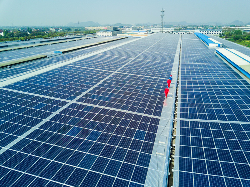 4月13日，工作人员在位于浙江省德清县的远大钢构屋顶光伏发电项目，查看光伏发电情况及相关设备。该屋顶光伏发电项目于4月初刚刚并网发电，光伏面板近3万块，面积达到7万平方米，装机容量6.9兆瓦，可实现年发电量700万度。