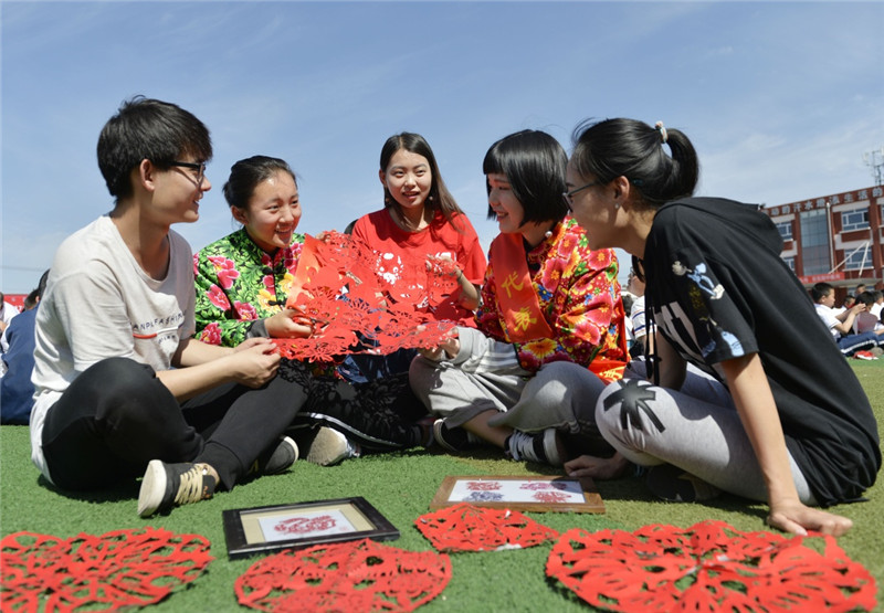 6月8日，在内蒙古呼和浩特市和林格尔县，和林格尔剪纸爱好者在交流技艺。