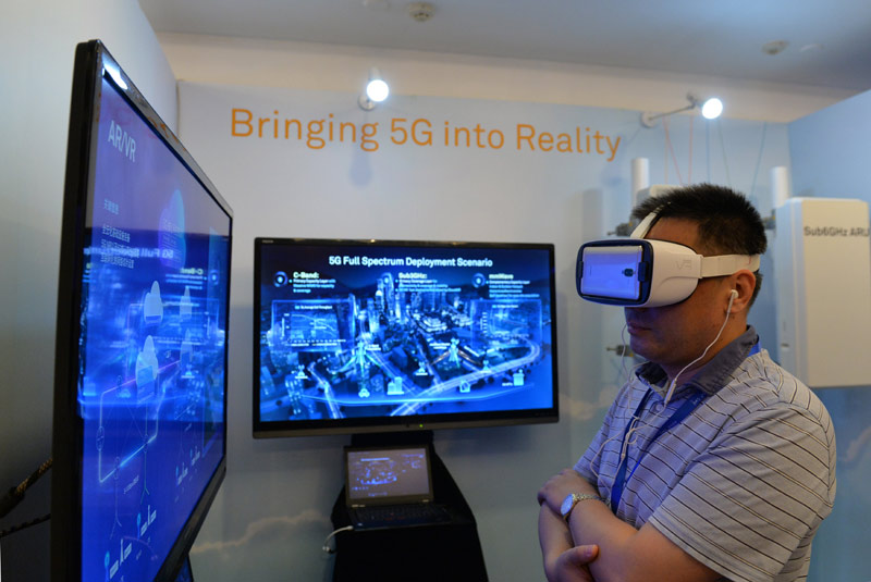 6月12日，嘉宾在峰会现场利用VR设备观看华为5G测试外场。